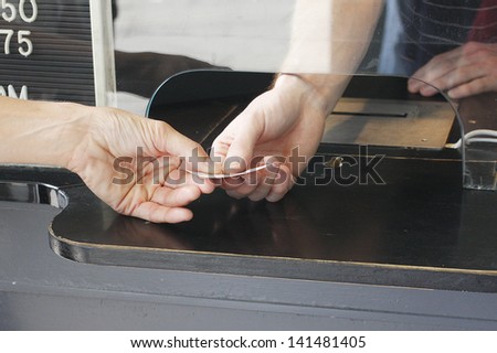 Buying a ticket at a  ticket booth.