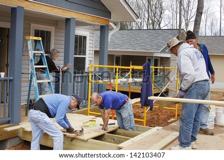 ASHEVILLE, NORTH CAROLINA, USA - APRIL 3, 2008: Volunteers for the nonprofit organization Habitat for Humanity work building new energy efficient houses for low income partner families in Asheville.