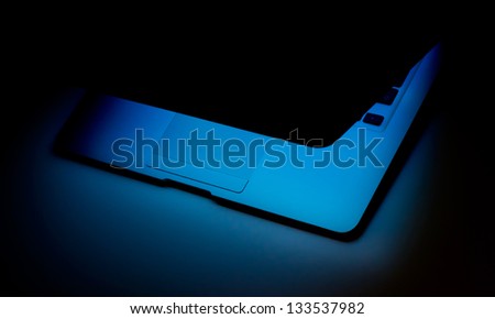 Laptop computer with screen half open on dark background isolated with clipping path