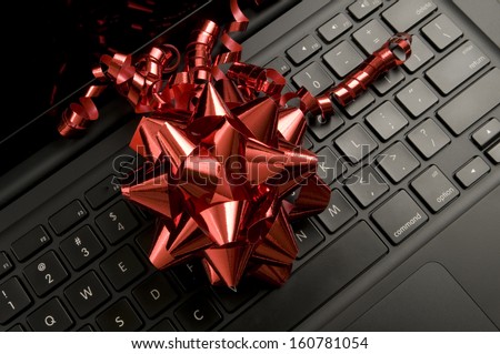 Red Christmas ribbon on black laptop keyboard