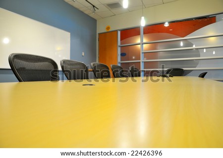 a table side view of a long conference room with phone