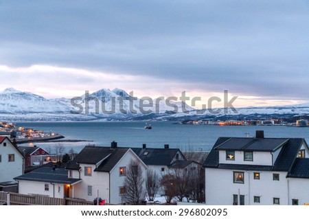 View on Tromso and surrounding mountains at dusk during polar night