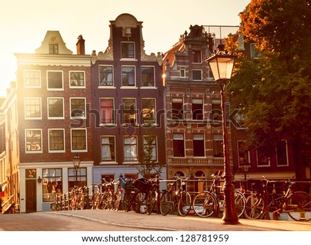 Sunset in Amsterdam (Netherlands), many bikes on a typical little bridge over a canal in Jordaan neighborhood