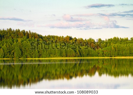 Beautiful lake view with a green trees reflection in the water