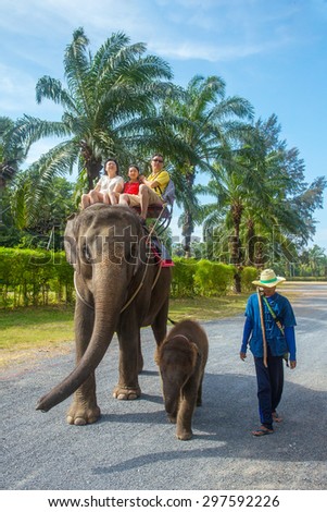 PHUKET, THAILAND - FEBRUARY 10: Unidentified family on an elephant ride tour with small baby elephant on February 10, 2015 in Phuket, Thailand.