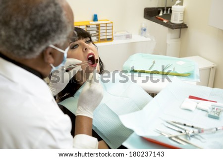 african american dentist or dental tech checking teeth in an oral exam