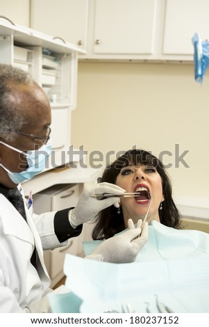 african american dentist or dental tech checking teeth in an oral exam