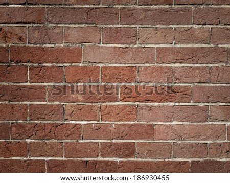 detail of  repair in red brick wall pointed  with light grey mortar.