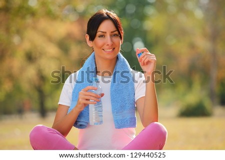 Young woman with a water bottle in hand after fitness