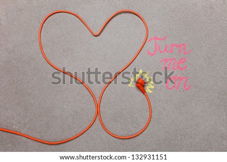 Orange electrical plug-in cable in shape of a heart