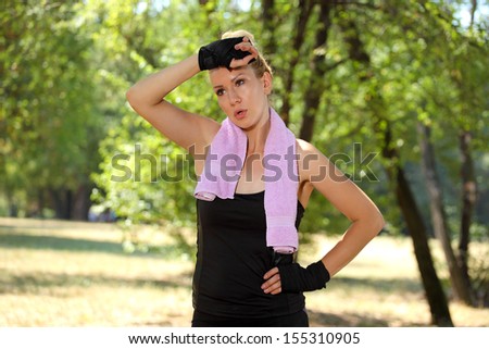 beautiful girl with yellow hair in the park wipes sweat