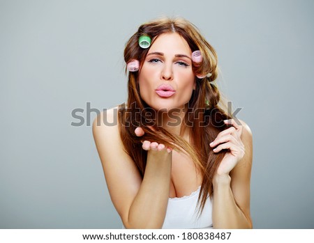 beautiful young  girl with brown hair,  dressing her  hair with green rollers