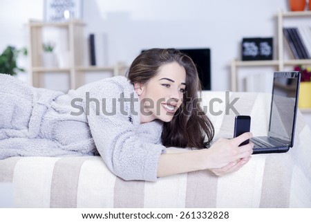 Beautiful woman in bed having tablet, computer and laughing, Woman in bed texting messages with  tablet and laughing in living room, Woman in bed taking selfie with phone