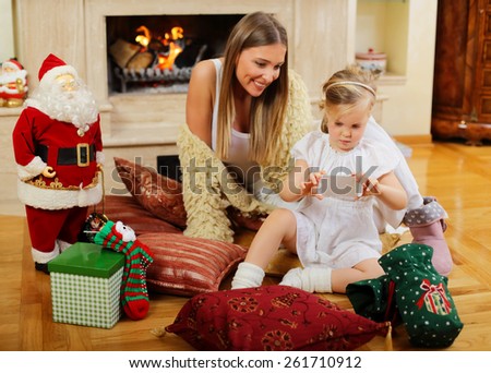 Mom and daughter siting in front of a fireplace