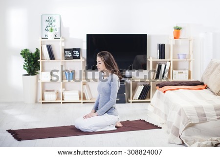 Woman is doing fitness at home on her living room floor.Fit woman doing yoga on mat at home in the living room