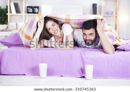 Happy couple under bed covers,morning scene