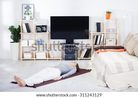 Woman is doing fitness at home on her living room floor.Fit woman doing yoga on mat at home in the living room