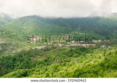 A town surrounded with forest under a mountain slope under the clouds, Istra, Croatia
