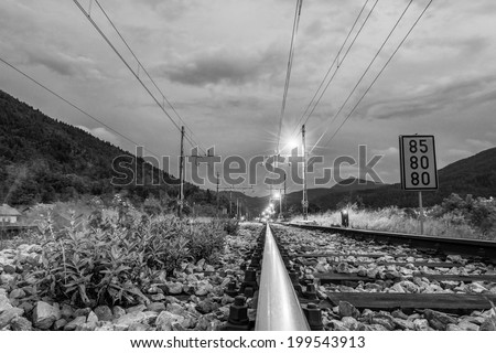 Railroad tracks running towards a junction and red sign lights indicating direction