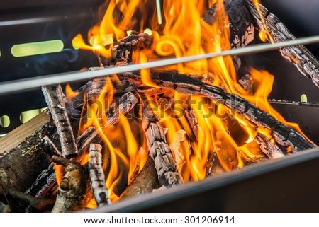 Preparing grill for barbeque. Fire blazing in portable grill.