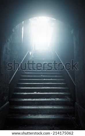 Old abandoned stairs going up to the light. Hope concept