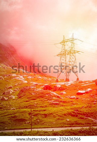Transmission tower in mountains, red toning applied, sunset effect