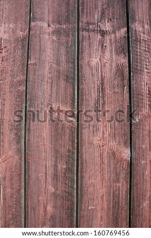 Old wooden barn with red stained wood grain texture. Closeup view for textured background. Wood texture from old barn