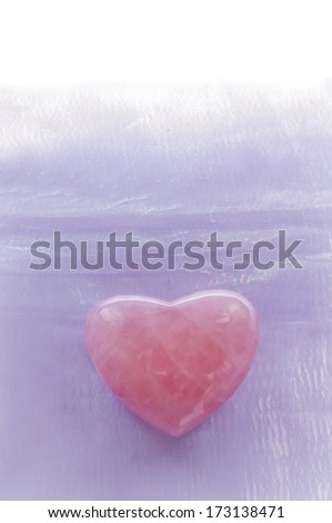 Rose quartz gemstone heart with lavender textured background./Rose Quartz Heart