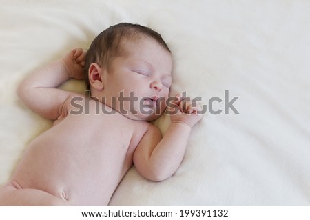 Newborn baby sleeping on white blanket in horizontal format.Newborn baby sleeping on white blanket