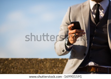 businessman with phone in hand, texting