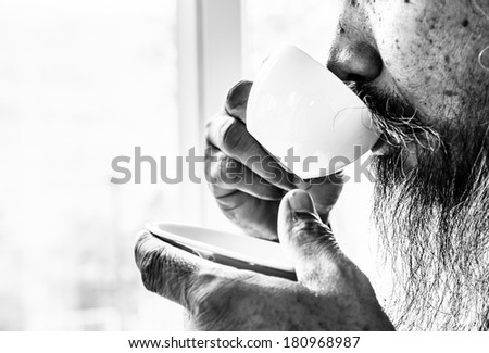 Old man with mustache and drinking coffee