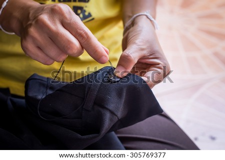 Woman's hand sewing fabric with sewing equipments