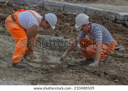 BELGRADE, SERBIA - AUGUST 06:  Workers work on the replacement of round manhole cover on the road, street reconstruction. At street Vojvode Stepe in August 2014.