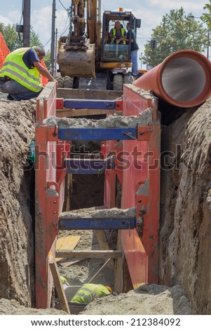 BELGRADE, SERBIA - AUGUST 09:  Workers in trench, working on a pipeline at construction site. Insulated pipes to connect a new buildings on heat system. At street Vojvode Stepe in August 2014.