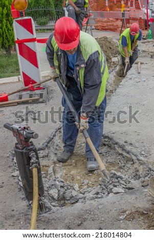 BELGRADE, SERBIA - SEPTEMBER 17:  Use pickaxe and shovel to dig trench for a new telephone and electricity cable. Selective focus and motion blur. At street Vojvode Stepe in September 2014.