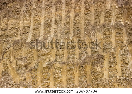 Dirt texture background, with small rocks and dust. Excavation dirt texture exposed.