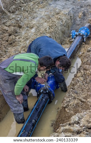 BELGRADE, SERBIA - DECEMBER 23: Installing water pipe valve in a trench. Laying a water pipeline, working on water valves. Selective focus. At construction site in December 2014.