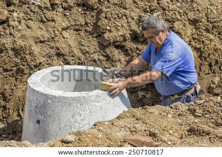 BELGRADE, SERBIA - AUGUST 28: Worker in trench installing storm drain system to reduce flooding during storms. At construction site in August 2014.