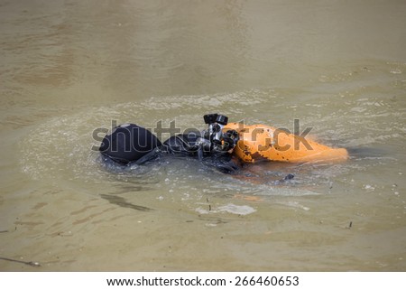 diver in diving suit and mask removing river hazards