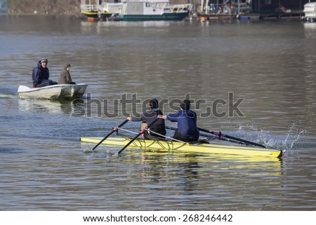 BELGRADE, SERBIA - MARCH 20: Rowing boat scull crew and coach in boat train on the River. Double sculls trailing. Focus on scull boat and shallow dof. At Sava river in March 2015.