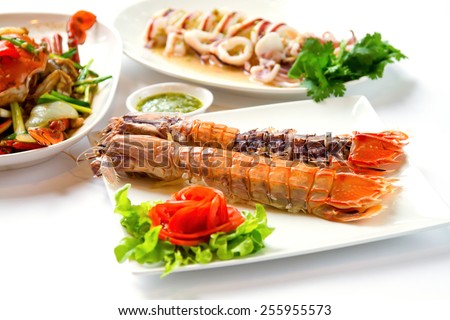 crayfish on white dish served with dipping sauce.