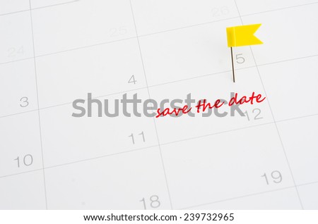 Push pin on a calendar-save the date