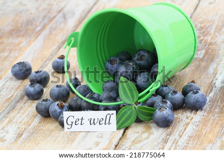 Get well card with blueberries scattered on wooden surface