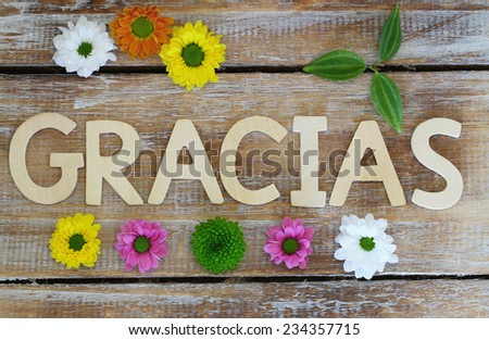 Gracias (which means thank you in Spanish) written with wooden letters and santini flowers
