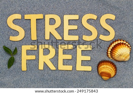 Stress free written with wooden letters on blue sand
