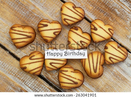 Happy birthday card with heart shaped cookies on rustic wood