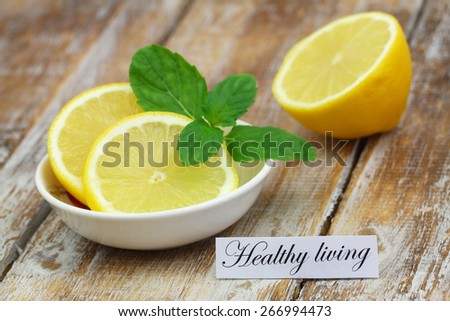 Healthy living card with lemon garnished with organic mint leaves on rustic wooden surface