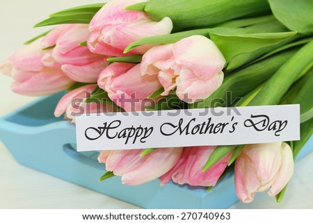 Happy Mother's day card with pink tulips on blue wooden tray