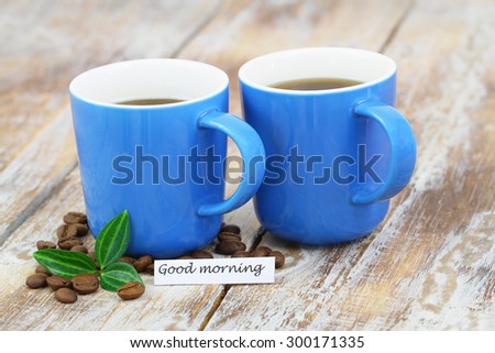 Good morning card with two blue mugs of coffee on rustic surface