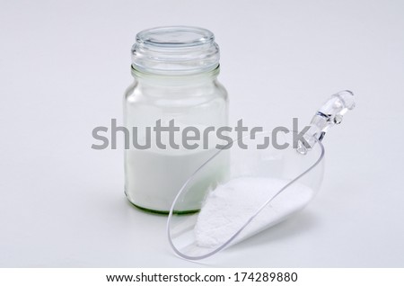 Sodium bicarbonate in a glass jar. White background.